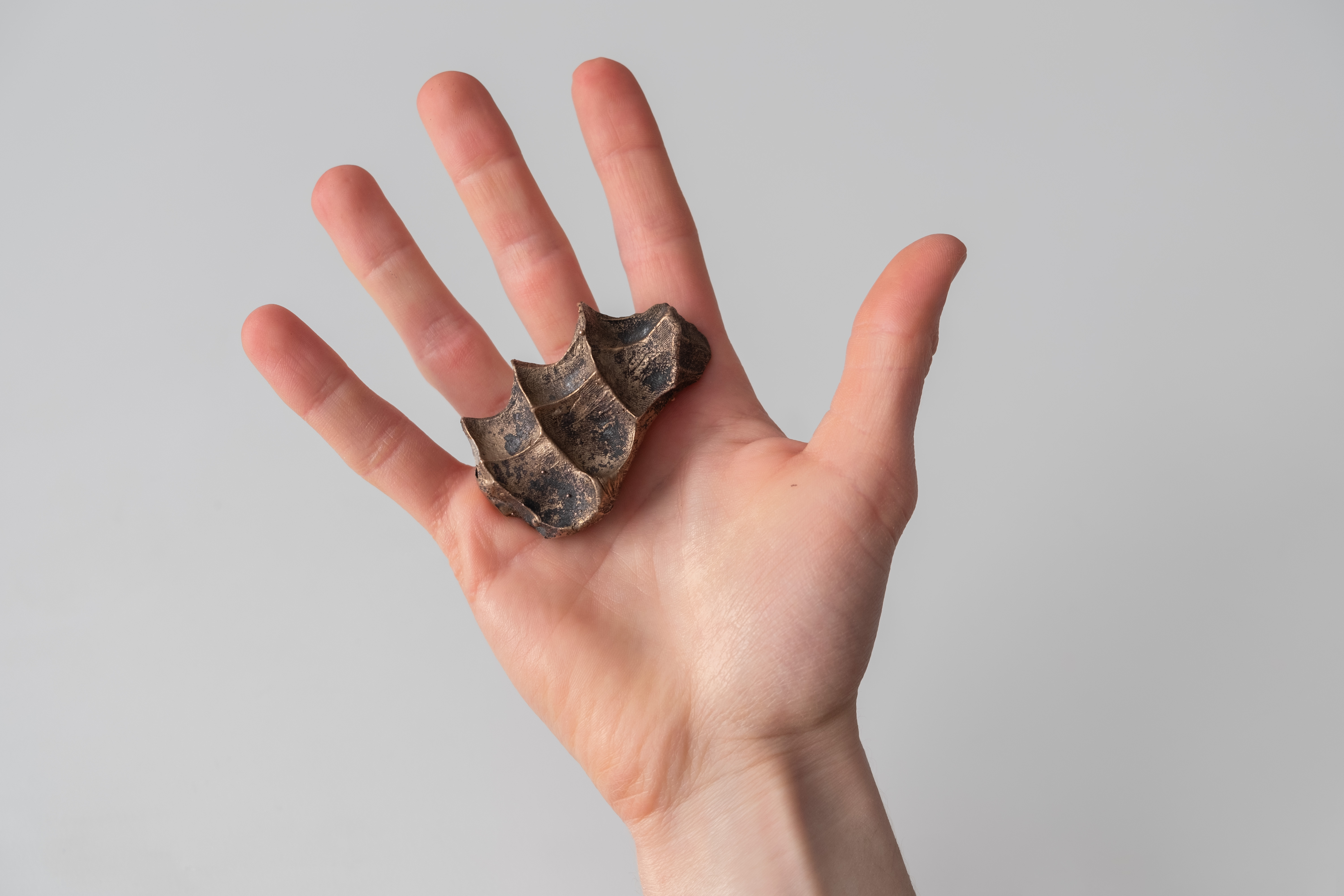 Finding Comfort in the Uncomfortable — hand with bronze sculpture